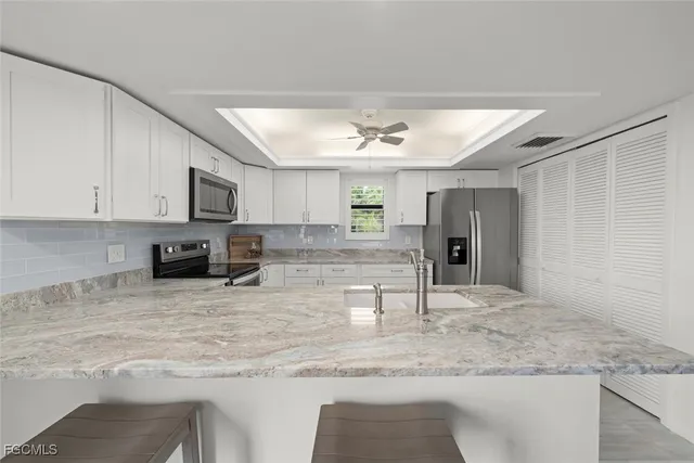 a view of a kitchen with kitchen island a sink stainless steel appliances and a counter top space