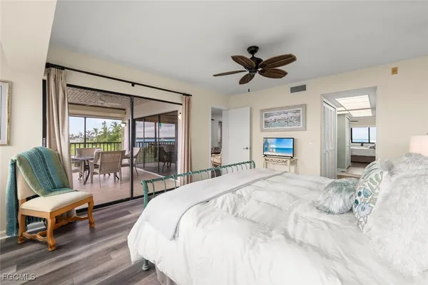 a spacious bedroom with a bed a couch and a large window