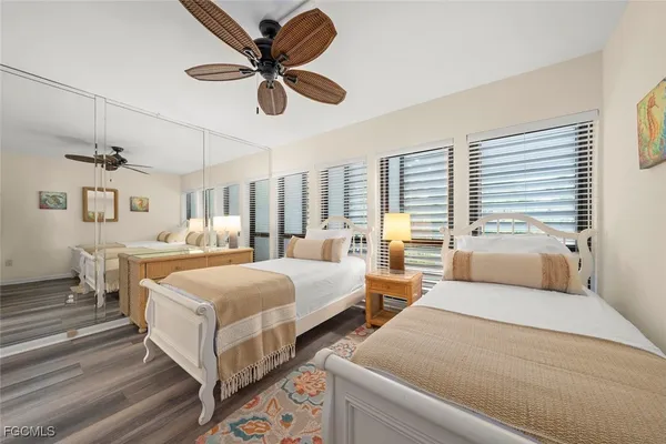 a bedroom with two beds and windows
