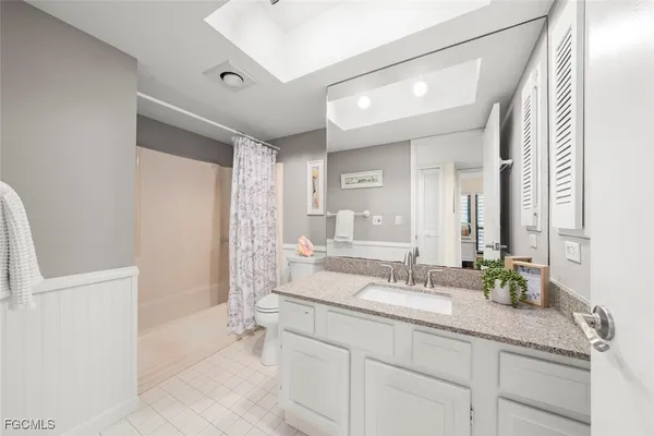 a spacious bathroom with a granite countertop sink a mirror and a