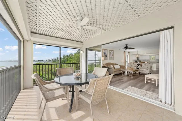 a dining room with furniture water view and a floor to ceiling window