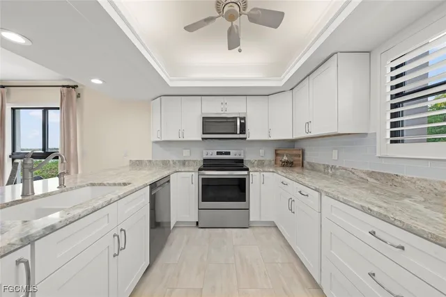 a kitchen with stainless steel appliances granite countertop a stove sink and cabinets