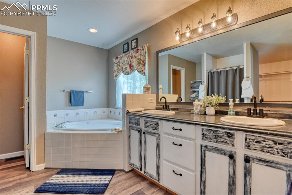 7863 Buschborn Road Peyton, CO 80831 - Photo 22 of 50 a spacious bathroom with a granite countertop sink and a mirror
