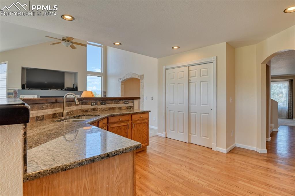 7863 Buschborn Road Peyton, CO 80831 - Photo 3 of 50 a kitchen with stainless steel appliances granite countertop a sink a stove and a wooden floors