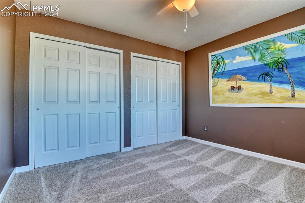 7863 Buschborn Road Peyton, CO 80831 - Photo 31 of 50 a view of a bedroom with a large bed and a chandelier