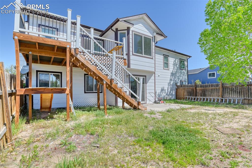 7863 Buschborn Road Peyton, CO 80831 - Photo 44 of 50 a view of a house with a yard and a wooden deck