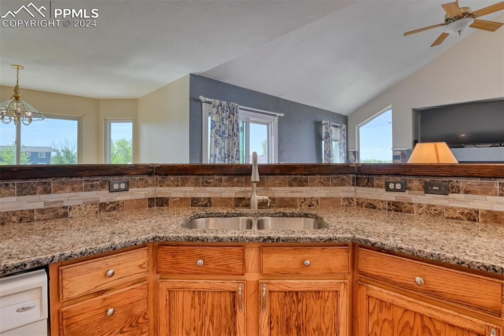 7863 Buschborn Road Peyton, CO 80831 - Photo 6 of 50 a kitchen with granite countertop a sink and a wooden cabinets