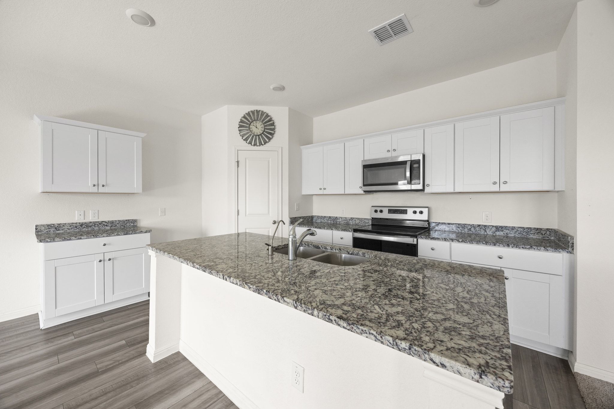 410 Magnum Force Drive Jarrell, TX 76537 - Photo 13 of 32 a kitchen with stainless steel appliances granite countertop a stove a sink and a microwave