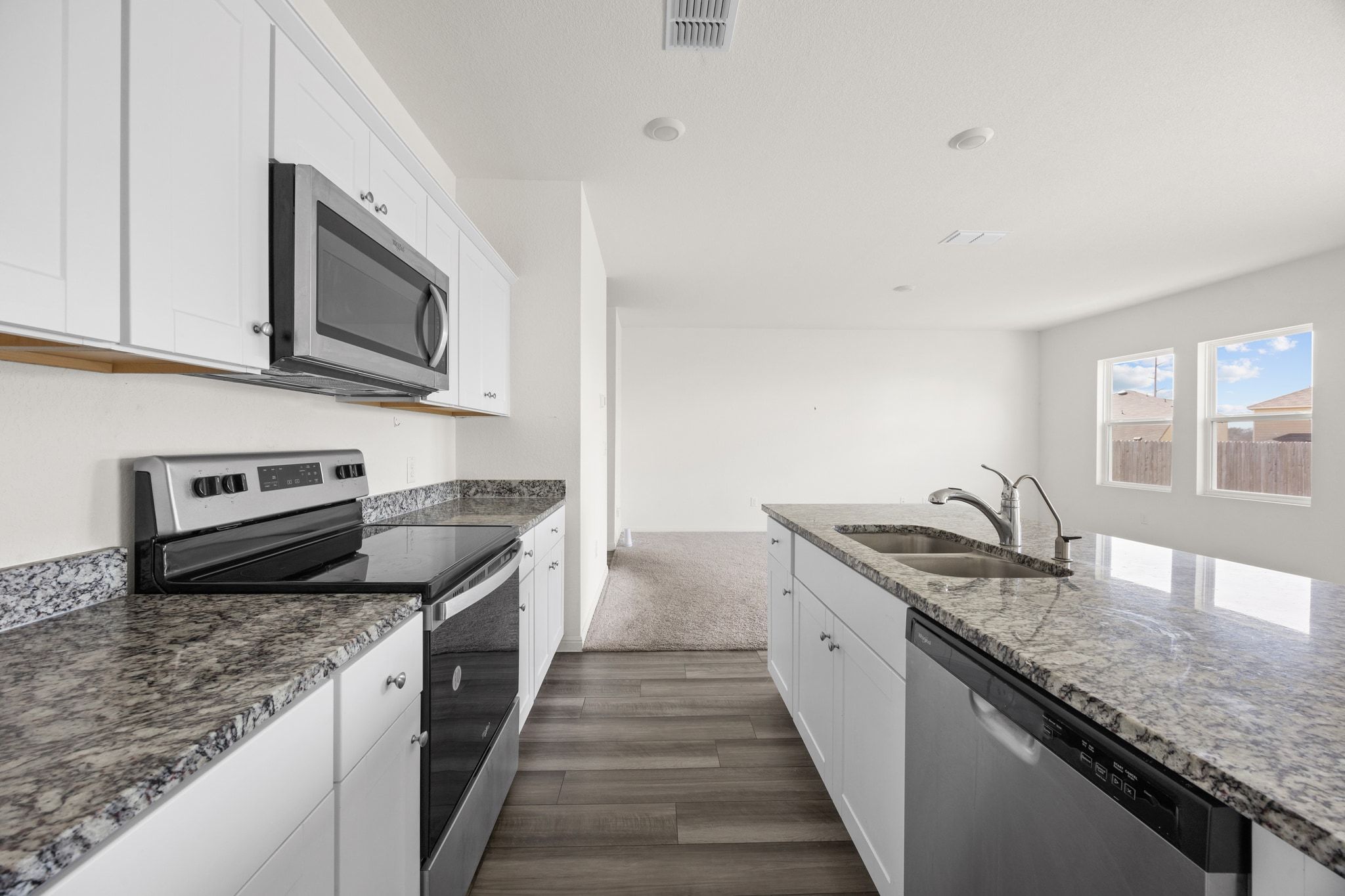 410 Magnum Force Drive Jarrell, TX 76537 - Photo 16 of 32 a kitchen with stainless steel appliances granite countertop a sink stove microwave and refrigerator