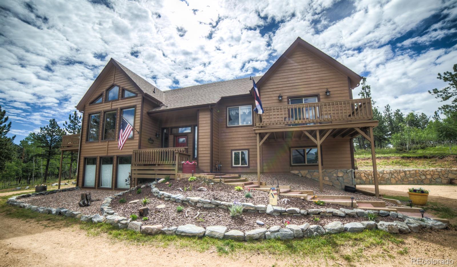264 Hangmans Road Bailey, CO 80421 - Photo 1 of 33 a front view of a house with garden