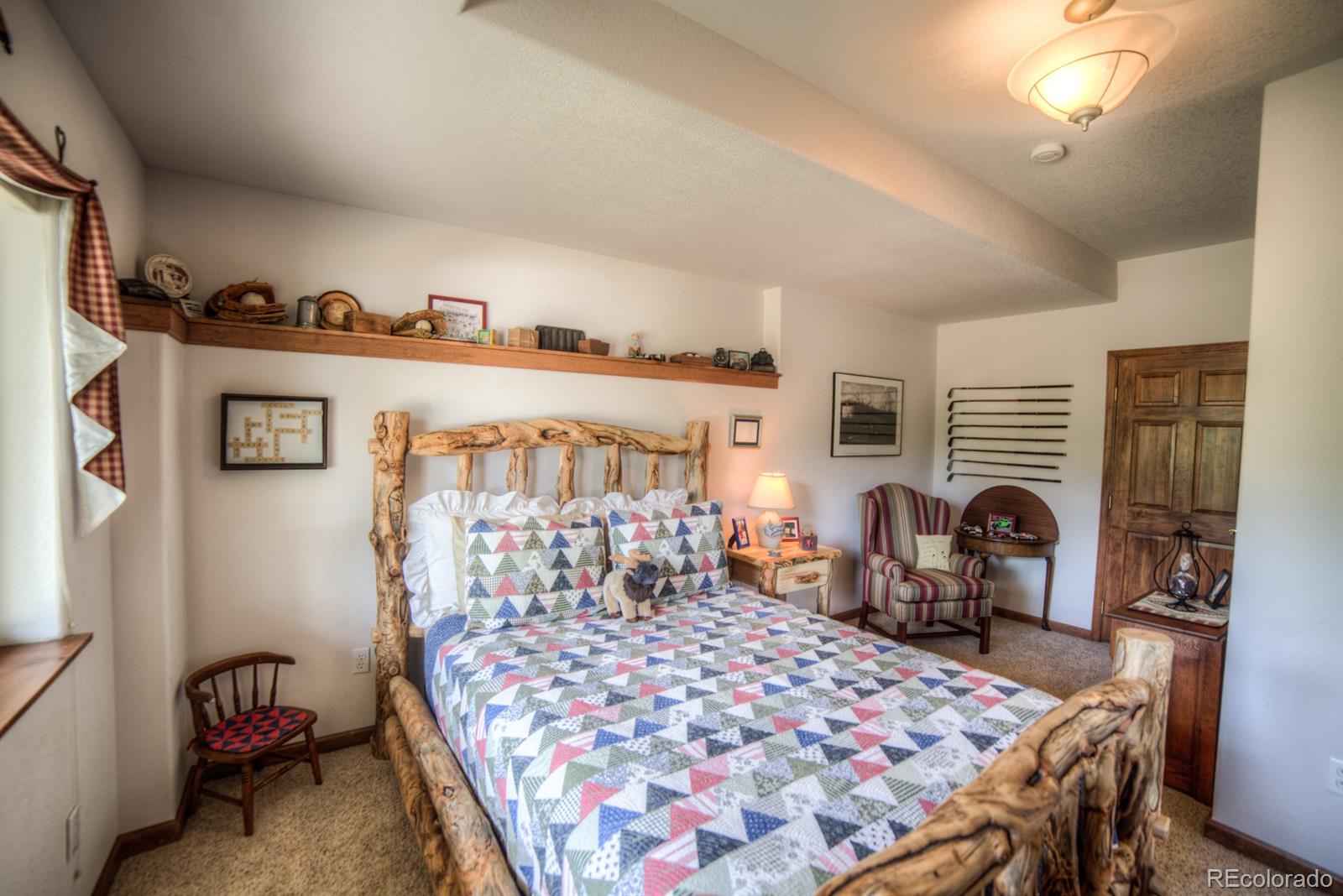 264 Hangmans Road Bailey, CO 80421 - Photo 23 of 33 a bedroom with furniture and a fireplace