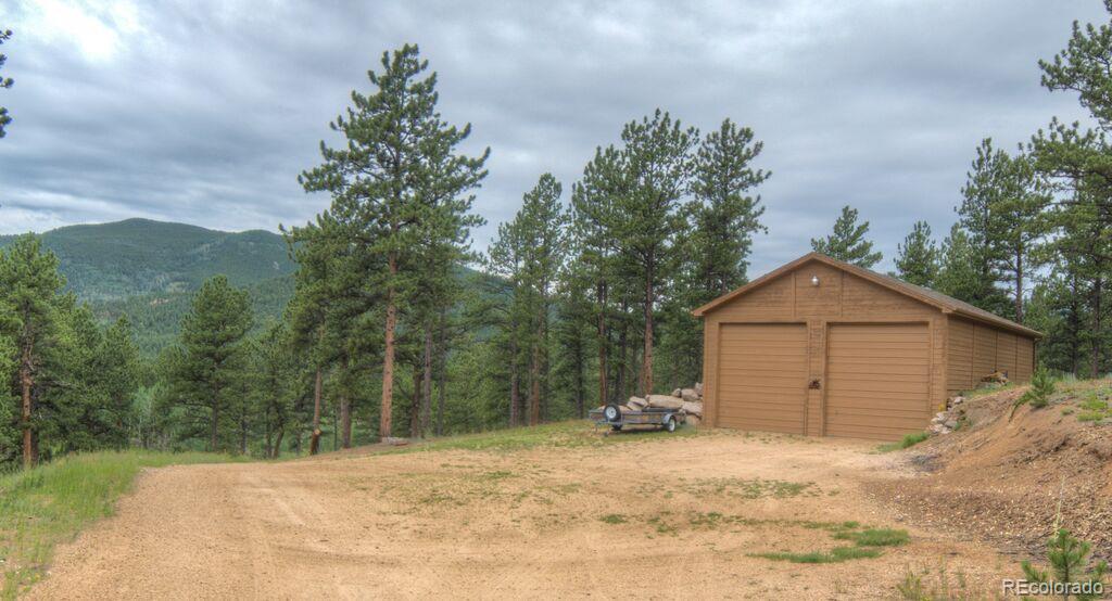 264 Hangmans Road Bailey, CO 80421 - Photo 25 of 33 a view of a wooden house with a yard covered with snow in the background