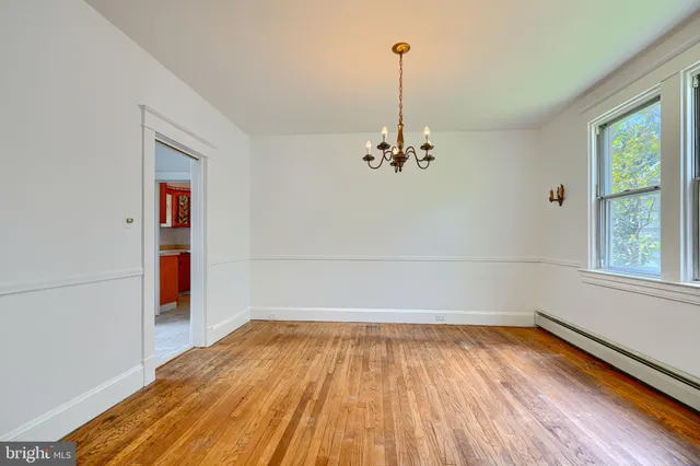 a view of a livingroom with a chandelier fan and wooden floor
