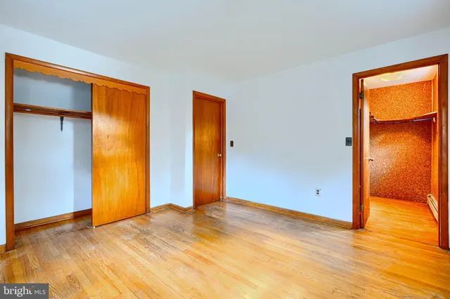 a bedroom with a bed and a lamp on the dresser