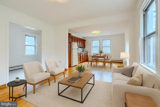 a view of a white house with a big yard plants and large trees