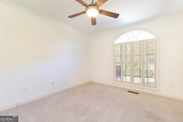 an empty room with a window and a fan