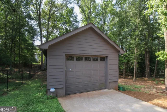a view of a small house and garage