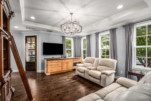 a living room with furniture flat screen tv and a large window