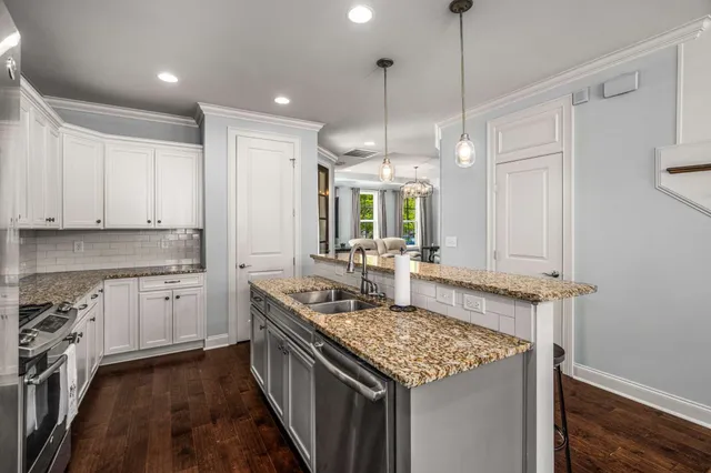 a kitchen with granite countertop a sink stove and cabinets