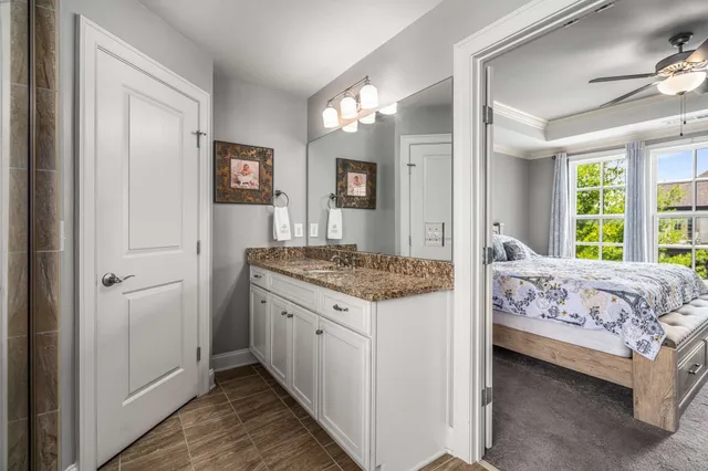 a living room with a bed and a dresser next to a window