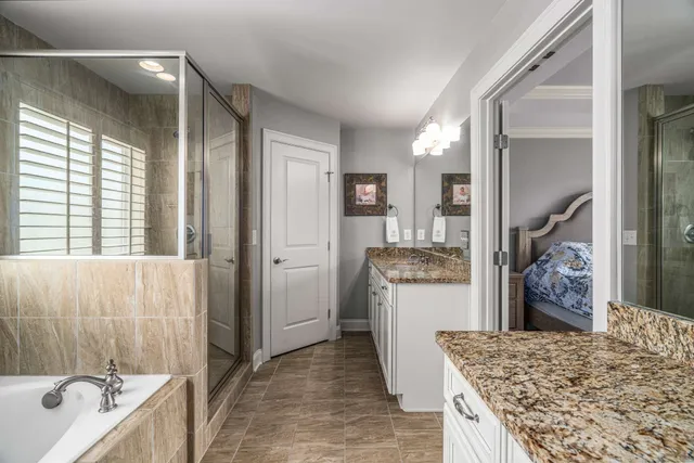 a bathroom with a granite countertop sink a mirror and shower