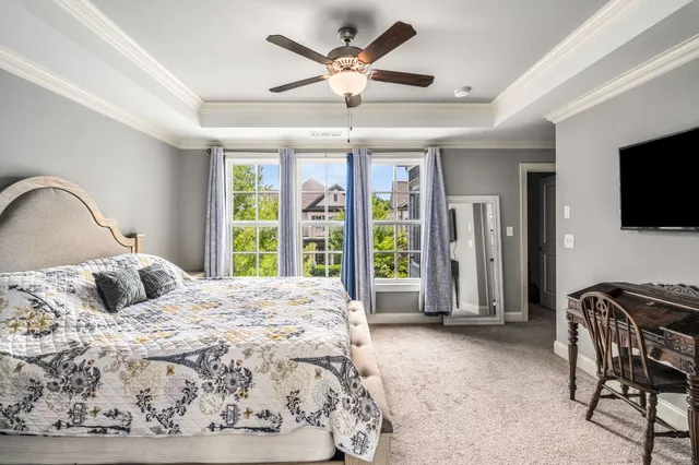 a bedroom with a bed and large windows