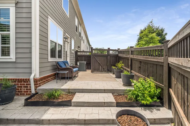 a view of a patio with couches table and chairs and potted plants