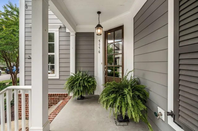 a view of a house with a yard and potted plants