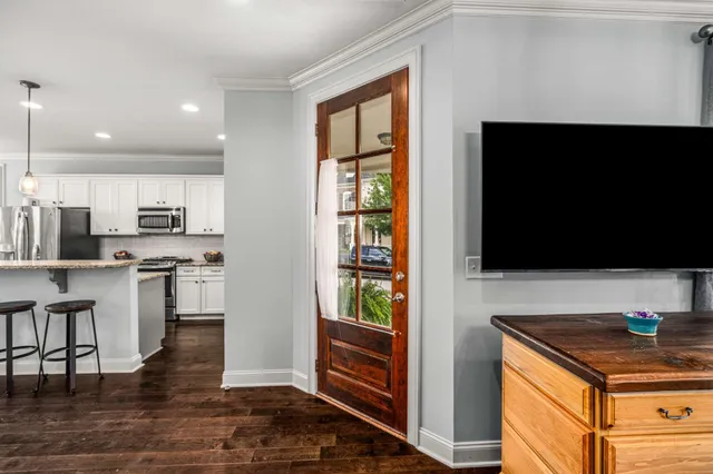 a living room with stainless steel appliances kitchen island granite countertop a stove and a refrigerator