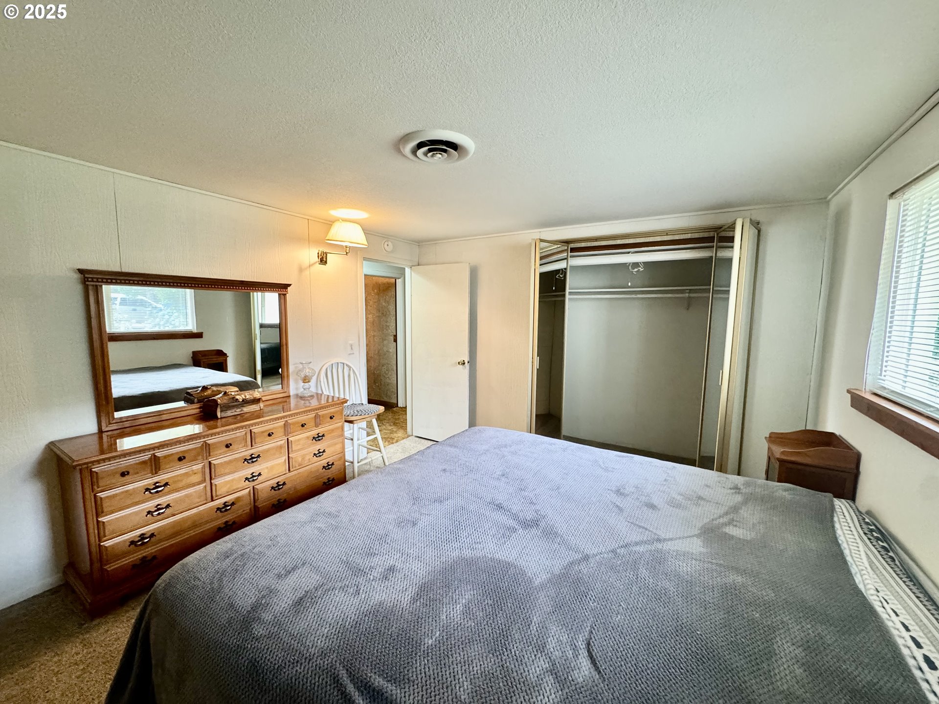 4990 Mitchell Loop Road Florence, OR 97439 - Photo 21 of 37 a bedroom with bed and large windows