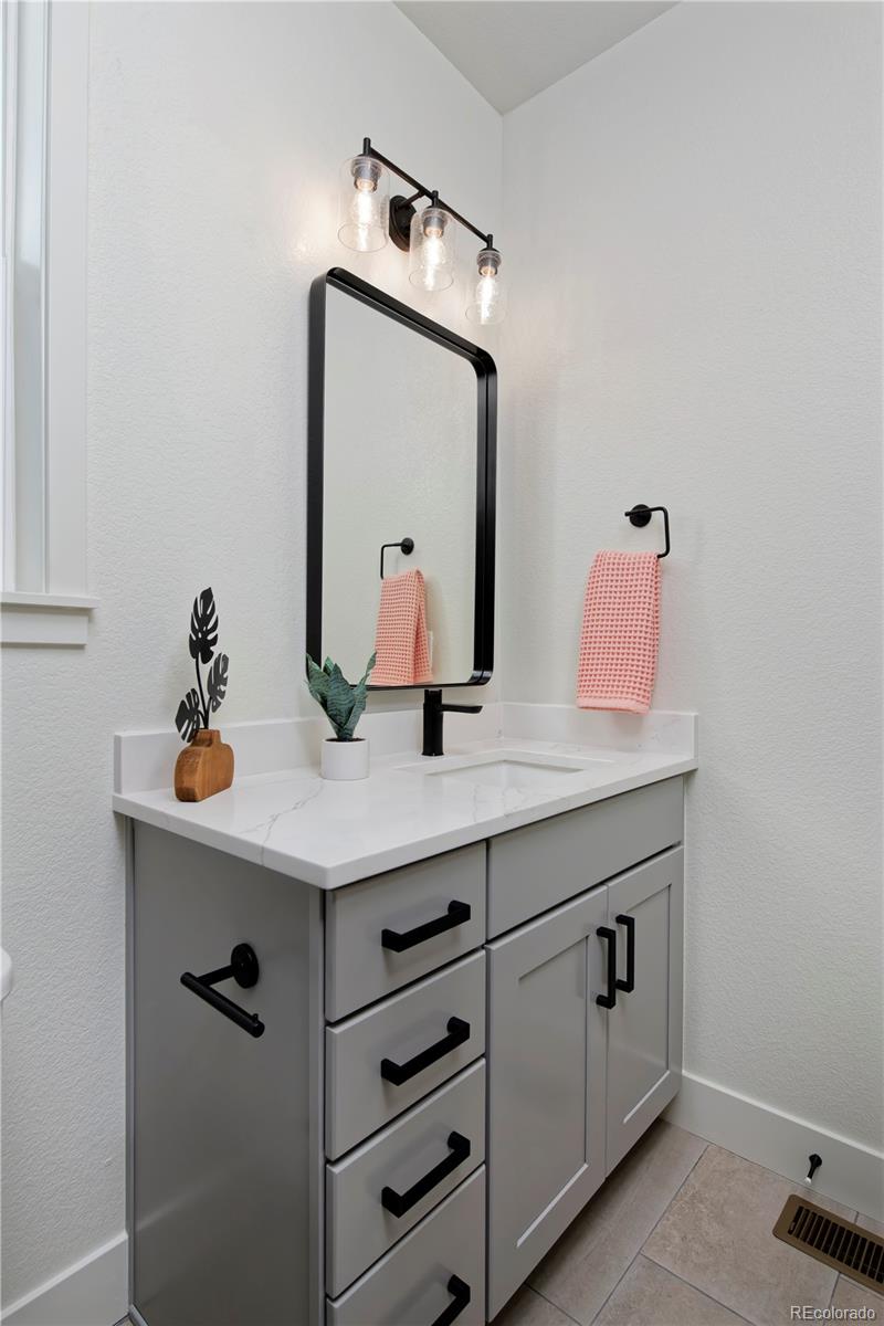 10884 Lyric Street Lone Tree, CO 80134 - Photo 4 of 8 a bathroom with a sink a mirror and vanity