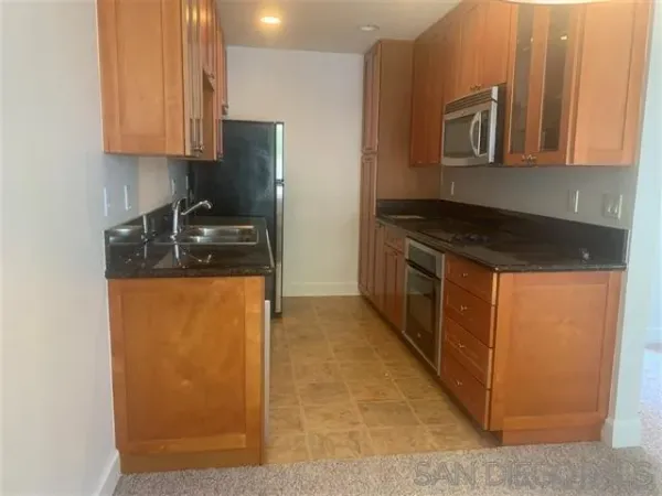 a kitchen with stainless steel appliances granite countertop a stove a sink and a microwave