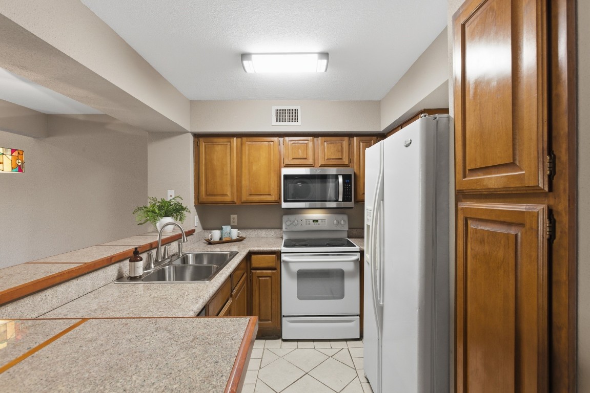 2425 Holly Hall Street, Unit 100 Houston, TX 77054 - Photo 18 of 45 Ample neutral wood cabinets in this bright and cheery kitchen!