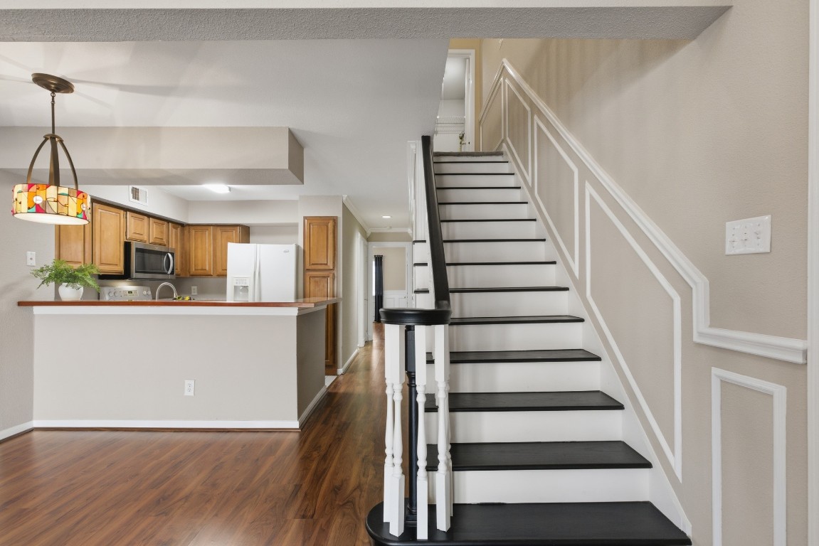 2425 Holly Hall Street, Unit 100 Houston, TX 77054 - Photo 26 of 45 Appealing statement staircase with dark wood stained steps with white balusters.