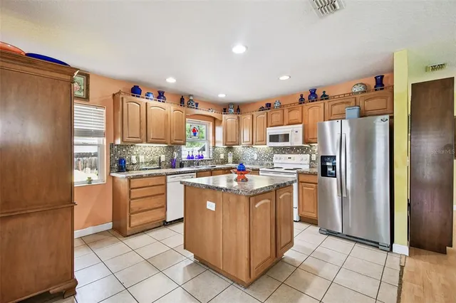 a kitchen with granite countertop a stove sink and cabinets