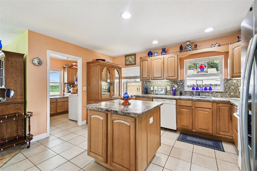 87 Lone Star Street Umatilla, FL 32784 - Photo 14 of 59 a kitchen with granite countertop a stove sink and cabinets