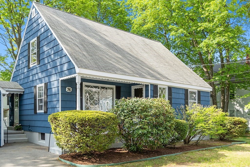 74 Viola Street Lowell, MA 01851 - Photo 2 of 35 a view of a house with brick walls plants and large tree