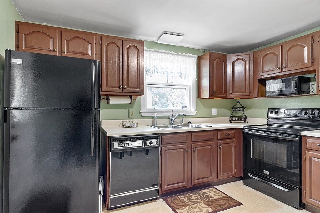 74 Viola Street Lowell, MA 01851 - Photo 22 of 35 a kitchen with a sink stove and refrigerator