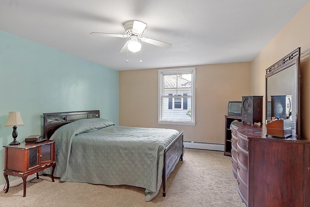 74 Viola Street Lowell, MA 01851 - Photo 27 of 35 a bedroom with a bed and a chandelier