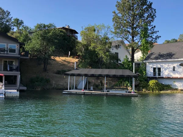 a view of house with swimming pool and outdoor seating