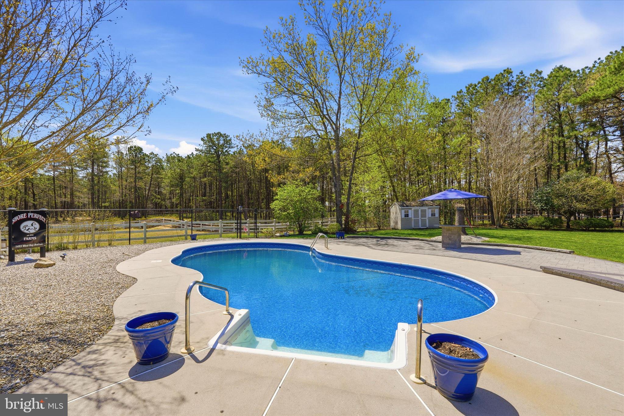 176 Warren Grove Road Barnegat, NJ 08005 - Photo 51 of 71 a view of a swimming pool with a bench and some trees