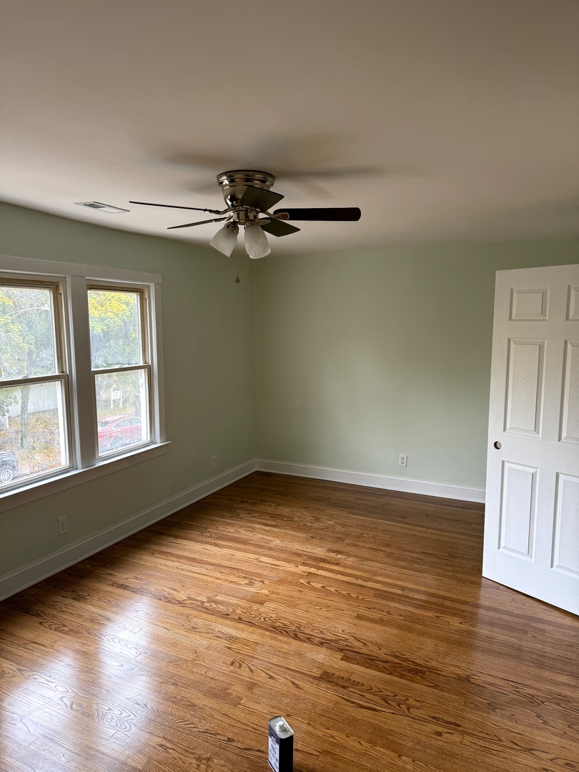 7744 South Champlain Avenue Chicago, IL 60619 - Photo 19 of 21 a view of an empty room with wooden floor and a window