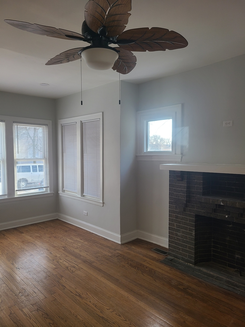 7744 South Champlain Avenue Chicago, IL 60619 - Photo 4 of 21 a view of an empty room with a window and wooden floor