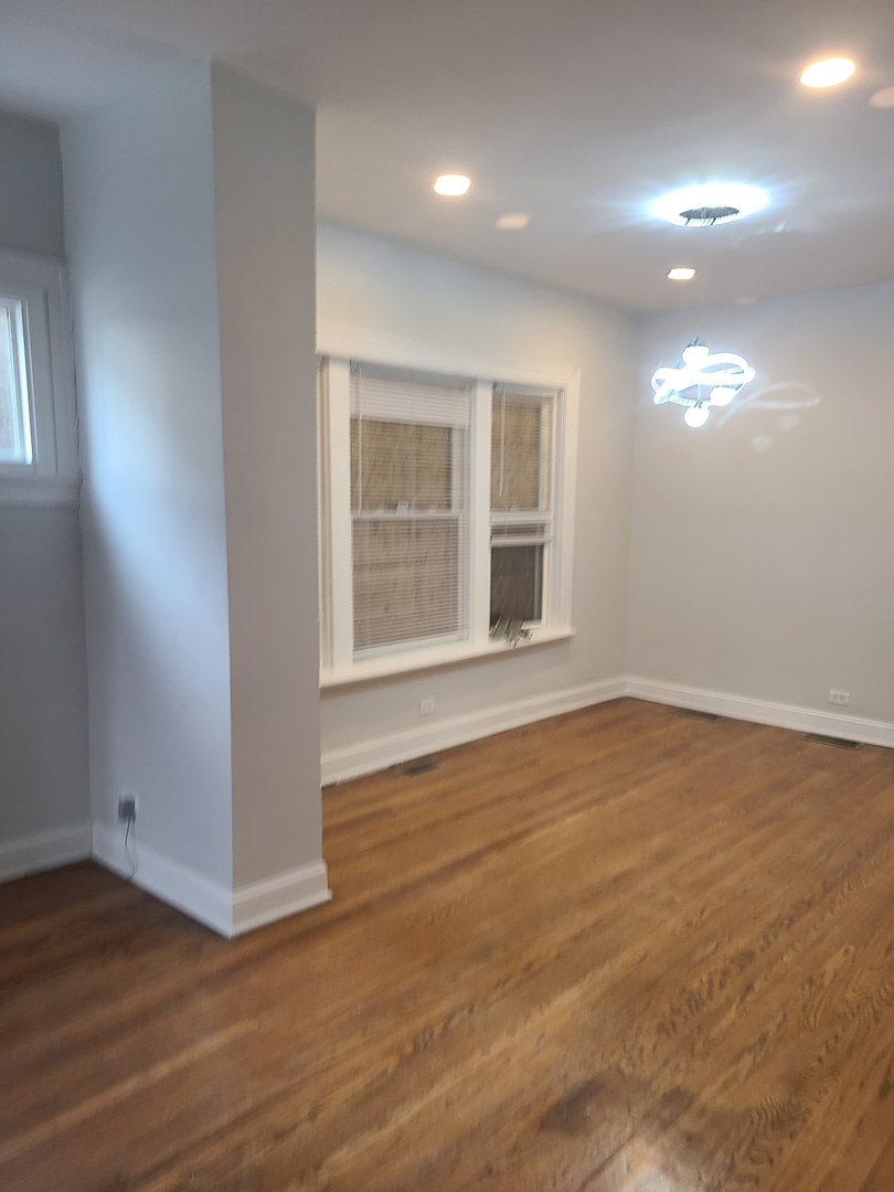 7744 South Champlain Avenue Chicago, IL 60619 - Photo 9 of 21 an empty room with wooden floor and windows