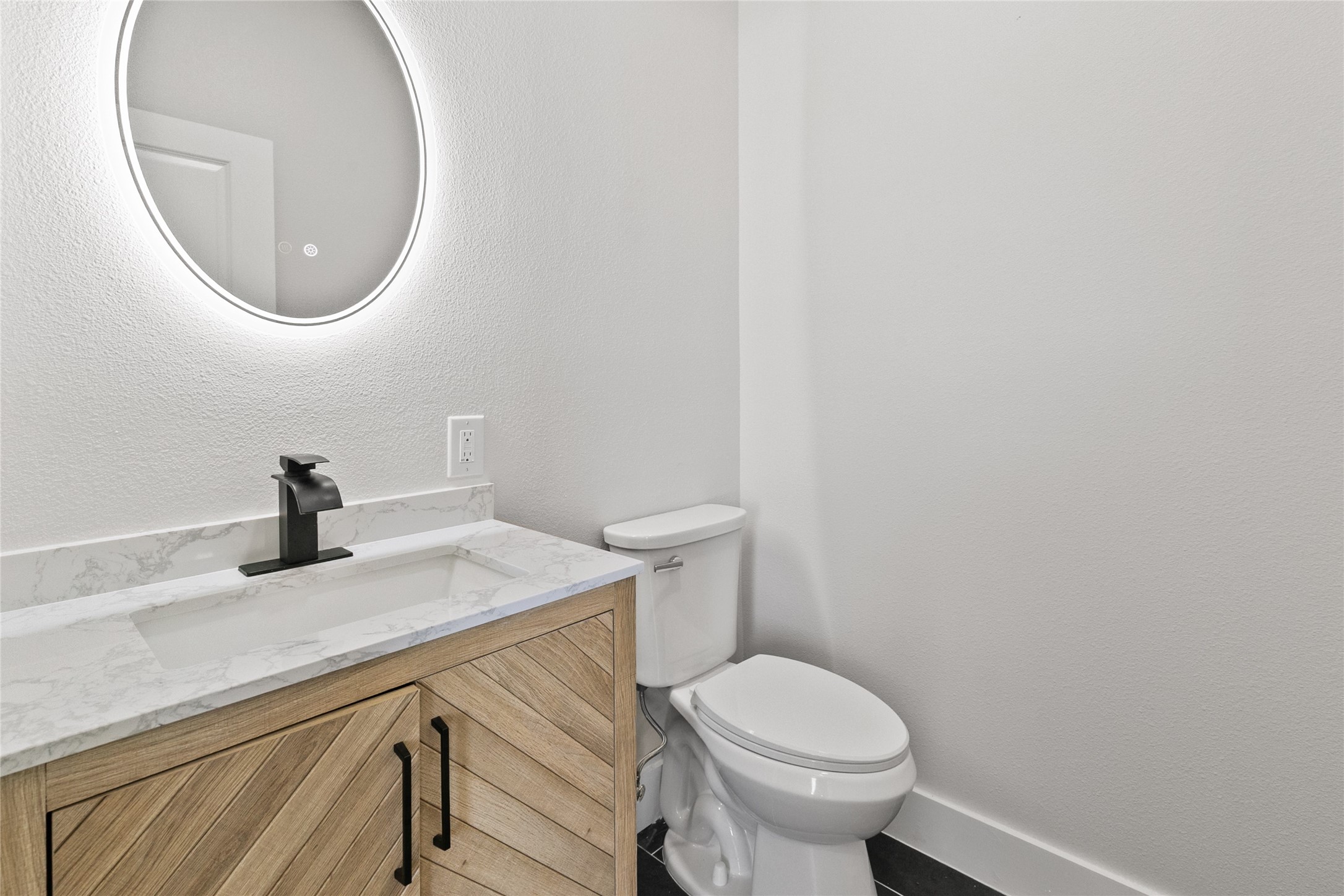619 Chuckwagon Trail Angleton, TX 77515 - Photo 32 of 37 Half bath conveniently located near the entryway and home office, featuring modern finishes and an illuminated mirror.