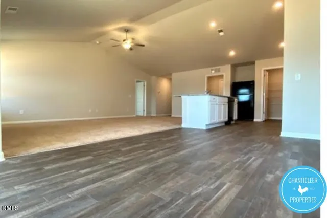 an empty room with wooden floor and a ceiling fan