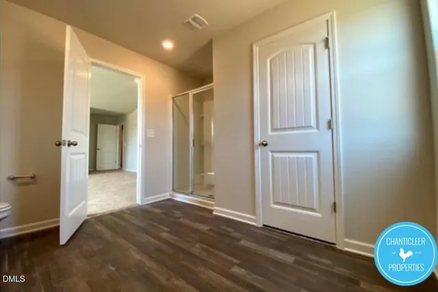 an empty room with wooden floor and mirror