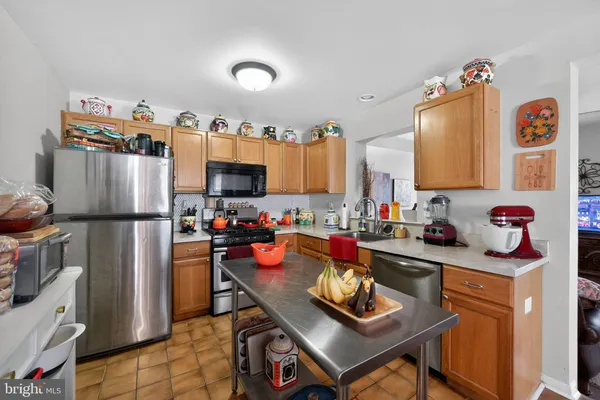 a kitchen with stainless steel appliances granite countertop a refrigerator sink and stove