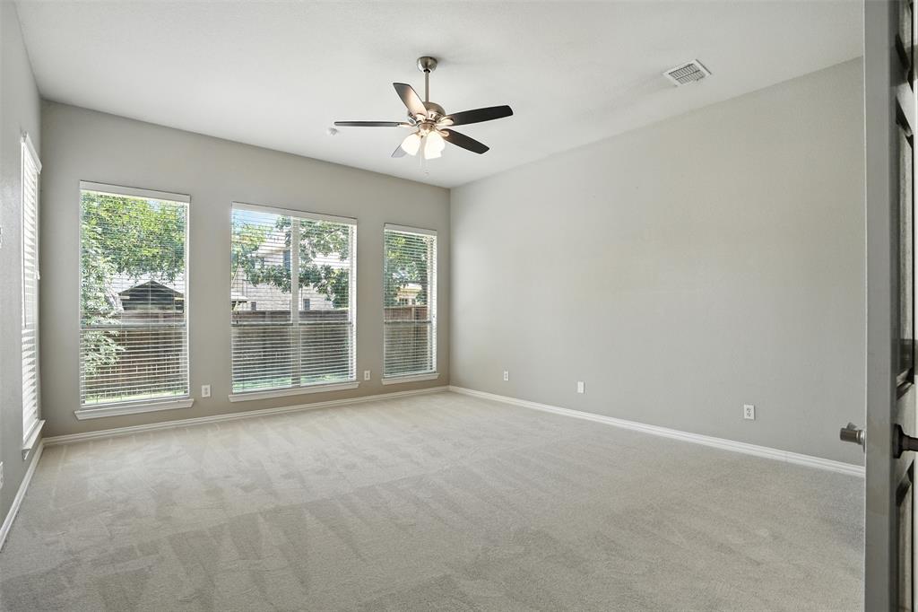 8220 Holliday Road Lantana, TX 76226 - Photo 17 of 40 Spacious room featuring multiple windows with blinds, light gray wall paint, and a ceiling fan with integrated lighting