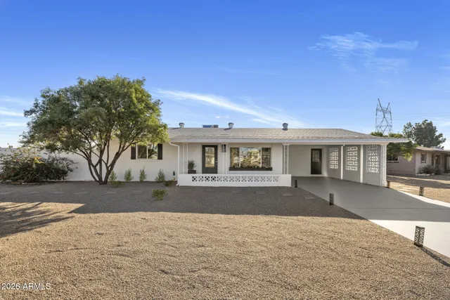 a front view of house with yard and trees in the background